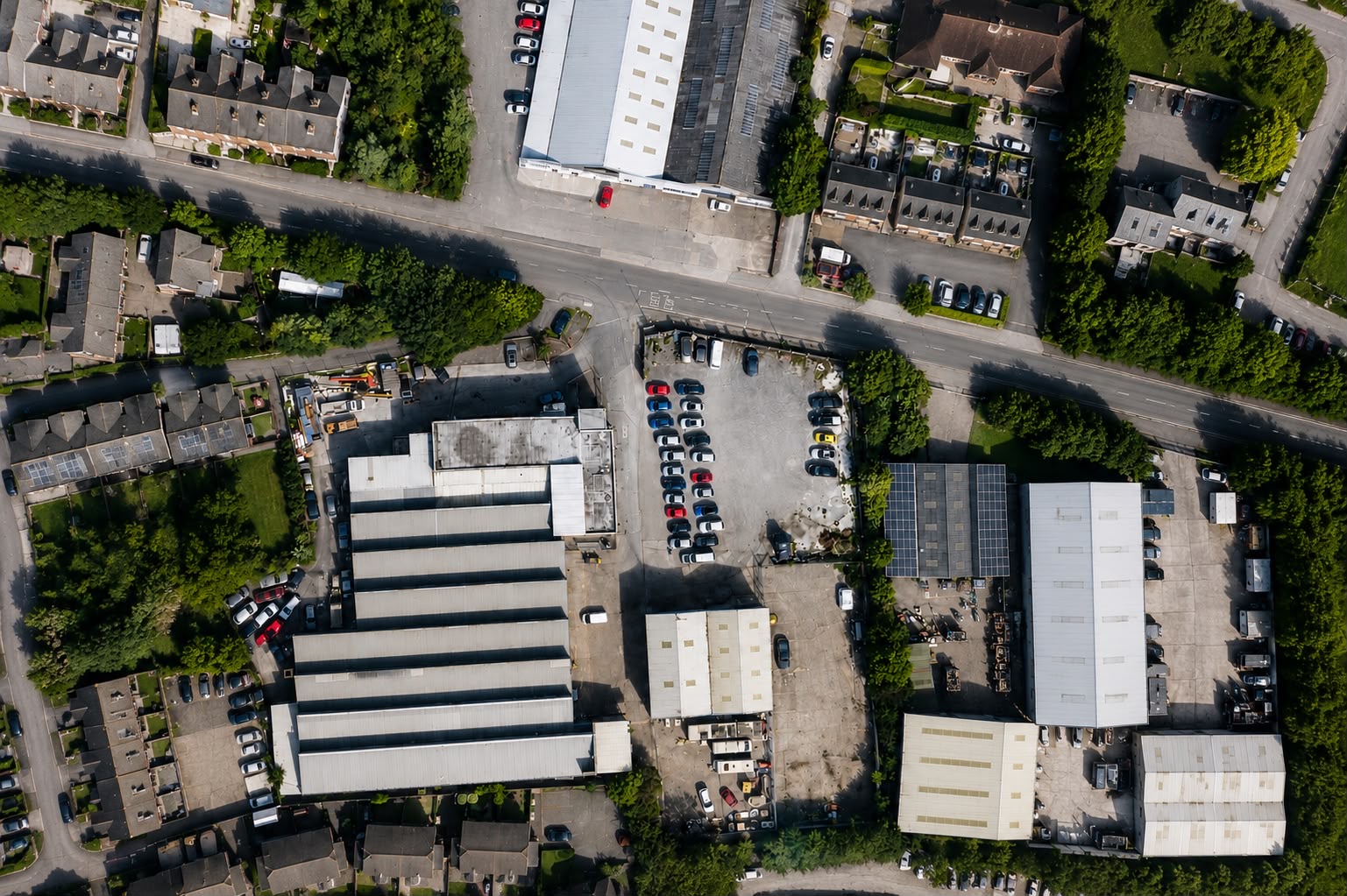 Aerial view of industrial units and yards surrounded by housing