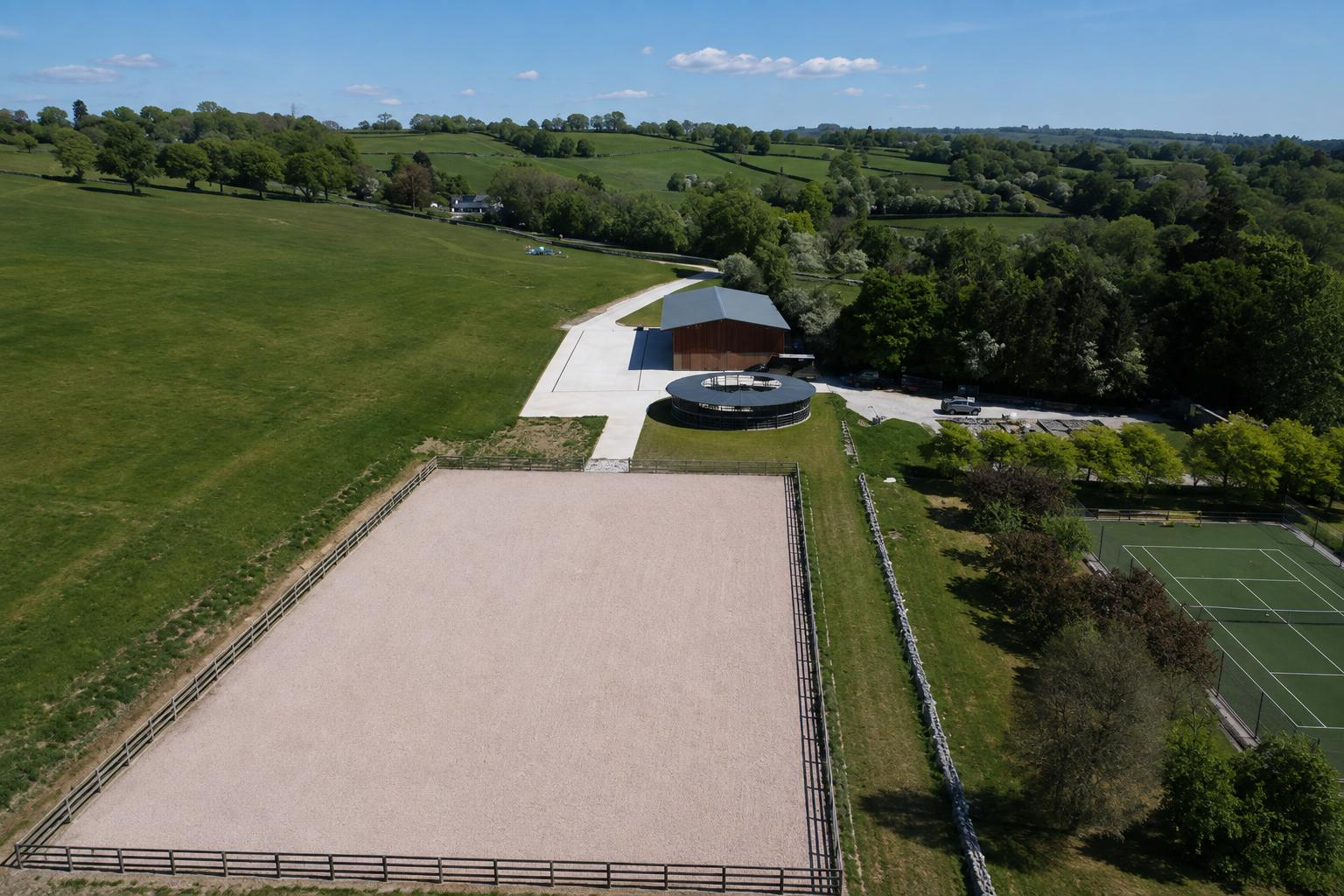 Aerial view of an equestrian facility with ménage, horse walker and American barn